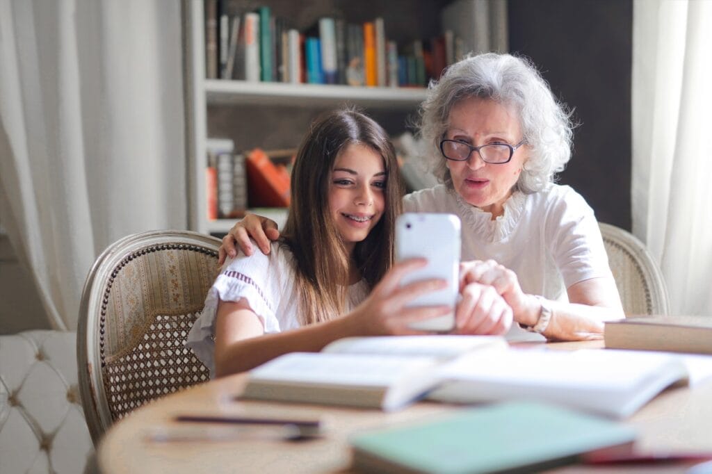 Teenager showing her grandmother how to use technology to improve her ability to age in place.