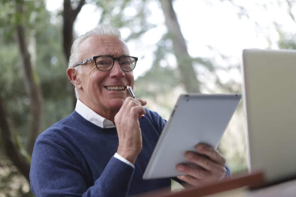 Aged gentleman using modern technology to connect with grandchildren.
